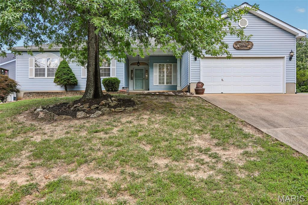 RAINTREE RANCH on quiet street with a TRIPLE LOT and parklike setting! Over 1800 SF of main floor living space plus a partially finished Lower Level makes this a must see!  You'll love the open floor plan featuring a tile foyer, gleaming hardwood floors in the living room - hall - primary suite, stone front fireplace and formal dining area with chandelier. The kitchen has its own breakfast area with tall windows overlooking the beautiful landscaped backyard and paver patio area. A breakfast bar, tall cabinetry make this a chef's corner! Stainless steel appliances, solid surface counters, recessed double-sink and a Garden Window for those herbs you'll want to grow yourself! Main floor launder too! The Primary Bedroom has hardwood floors and has a corner jet tub, separate shower and walk-in closet. The Lower Level has some finishes and needs some more! You'll have to install some new flooring and add a little drywall as there was a sump pump failure and it caused some minor damage which has been mitigated. The back yard has a covered porch, paver patio, retaining wall and more. There is a third car width concrete area alongside the existing driveway and it continues alongside the house so you have plenty of room for that boat, rv or hotrod! Your Country Club dues include free golf for your family, access to the new Pickleball Courts, beautiful pool and rec areas too.  Raintree also provides access to all 4 lakes including the 125 acre lake where you'll find people skiing, fishing, using the beach area and pavilion. There is a camping area as well. The fishing is great here! Come check it out!