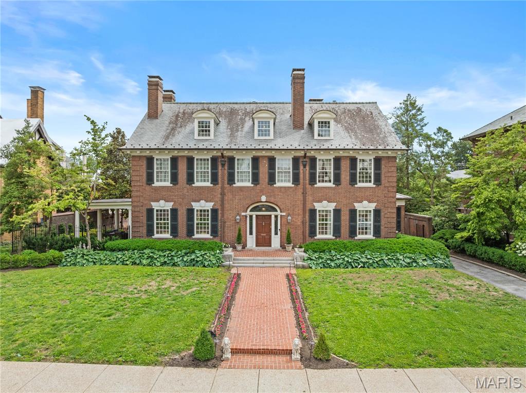 Located on one of the most sought-after streets in St. Louis is this 1906 Georgian Revival masterpiece designed by renowned architect James Jamieson. This home presents a marriage of historic grandeur and updated sophistication. The stately façade, elegant proportions, and timeless presence command attention from the moment you arrive. Step inside to a dramatic foyer, where an oversized window atop the grand staircase bathes original millwork and exquisite craftsmanship in natural light. The paneled living room, anchored by an immense original stone fireplace, is enveloped in beautifully preserved woodwork, antique doors, and intricate trim. Covered porch off of the living room. Folding paneled doors reveal a formal dining room with stylish fabric padded walls, offering an ideal backdrop for stylish entertaining. The moody, rich color-drenched butler’s pantry boasts striking granite countertops, flows seamlessly into a chef-caliber kitchen outfitted with custom cabinetry, premium appliances, and picturesque views over the backyard and heated pool. Adjacent, the sunroom features a newly added full bathroom, perfectly appointed to serve as a pool bath. Upstairs, the expansive primary suite boasts a private office, a generous walk-in closet, and a marble-clad bathroom, complete with an oversized soaking tub and separate shower. An additional en-suite bedroom enjoys its own marble-accented bath. A spacious recreation room with a fireplace opens to a rooftop terrace. The third-floor delights with painted wood floors, three inviting bedrooms, two full bathrooms, and a versatile bonus room, perfect as a studio, office, or playroom. Outdoors, multiple entertainment spaces frame the heated pool, while the oversized, detached two-car carriage house offers an upstairs space ready for your custom vision.
