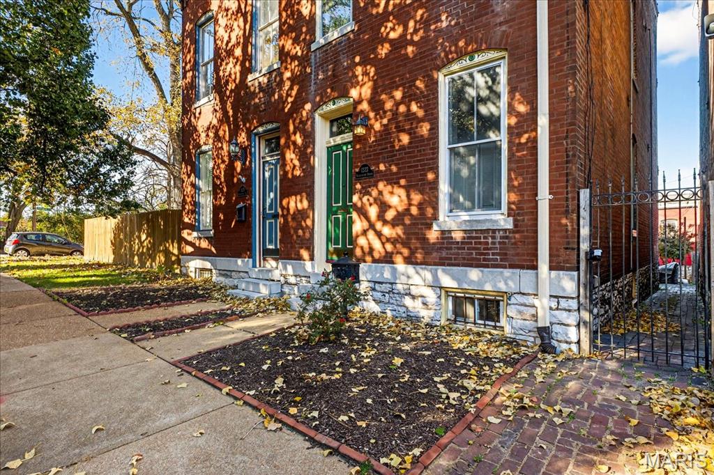 Welcome to this stunning Soulard gem! Built in 1917, this three-story home blends historic character with modern updates, offering an ideal primary residence or investment opportunity. From the moment you arrive, the classic curb appeal radiates the unmistakable Soulard charm. Step inside to soaring ceilings accented by recessed lighting, an exposed brick wall, and gleaming original hardwood floors. The spacious living room is filled with natural light and flows seamlessly into the dining area—perfect for entertaining. The main level also features a half bath and an upgraded kitchen complete with white cabinetry, solid-surface countertops, stainless steel appliances, and direct access to the fully fenced backyard. Upstairs, the second floor offers two bedrooms and a full bath. The first bedroom boasts a generous closet and private access to the bathroom, making it an excellent option for a primary suite. The second bedroom opens to a charming balcony overlooking the backyard. The full bath includes a beautifully tiled walk-in shower and dual access from the hallway and bedroom.
The third floor is a showstopper—a versatile space that can serve as a large primary suite or a spacious recreation area. It features a walk-in closet, a large newly updated bathroom, and breathtaking views all the way to the St. Louis Arch. Outside, the fenced backyard is designed for relaxation and entertaining, with a large brick patio and green space for gatherings or quiet evenings. This is a great opportunity provides Soulard history with modern comforts. WELCOME HOME!