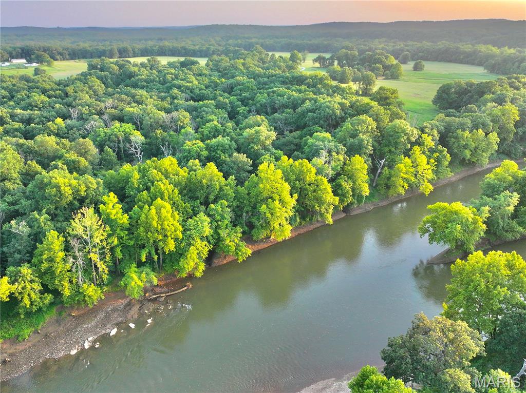 This 17.46 double tract offers the perfect blend of seclusion, recreation, and build-ready convenience. With over 380 feet of direct river frontage and a secondary deeded river access point just upstream, you’ll enjoy multiple access locations to some of the best fishing, floating, and relaxing the Ozarks have to offer.
Located less than 2 miles off Highway 54 along a private stretch of the Sac River,  the end of a dead-end county road, the property is accessed by a private road behind an electric gate providing both security and convenience. Electric is already run to the front of the property, making future development simple whether you’re planning a weekend cabin, hunting retreat, or full-time residence.
The land features a beautiful mix of open ground and mature timber with a prime open build area near the road while still maintaining excellent privacy. Large hardwoods create a tall shaded canopy throughout the property, while creeks bordering both sides add to the natural beauty and provide excellent wildlife travel corridors. Deer and turkey sign are abundant, making this an outstanding recreational tract for hunting and outdoor enjoyment.
The combination of river frontage, secondary deeded access, utilities, privacy, and build potential is hard to find in today’s market. Additional acreage is also available for purchase if you’re looking to expand. Whether you’re searching for a peaceful getaway or a future riverfront homesite, this secluded Sac River property checks all the boxes.
