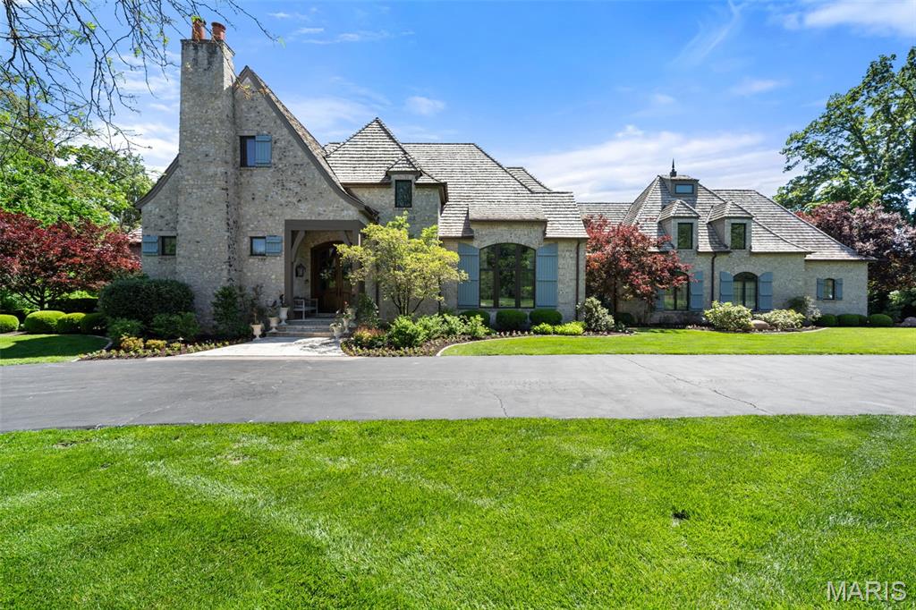 Surrounded by a canopy of mature trees, 10144 Winding Ridge Road is a rare expression of refined luxury, architectural sophistication, and uncompromising craftsmanship. This exceptional estate offers over 8,000 square feet of curated living space above grade, complemented by an additional 2,600 square feet of exquisitely finished lower-level amenities designed for elevated everyday living and grand-scale entertaining alike. From the moment of arrival, the residence commands attention with its timeless presence, private estate setting, and meticulous attention to detail. Every room has been thoughtfully designed to balance warmth and elegance, creating an atmosphere that is both impressive and deeply livable. Expansive interiors unfold with seamless flow, designer finishes, and beautifully scaled gathering spaces tailored for modern luxury living. Natural light pours through oversized windows, while sophisticated architectural elements and bespoke craftsmanship create a home of enduring distinction. The outdoor environment rivals an elite resort experience. A spectacular pool anchors the grounds, accompanied by two private hot tubs and multiple outdoor living spaces curated for relaxation, entertaining, and year-round enjoyment. The estate’s lush acreage provides exceptional privacy while remaining moments from the premier amenities of Ladue. The lower level transforms into an entertainment destination of its own, featuring a custom sports bar and lounge designed for unforgettable hosting experiences. Wellness and convenience are seamlessly integrated throughout the property with a dedicated fitness gym/studio, two full laundry rooms, a private apartment ideal for guests or multigenerational living, and an oversized four-car garage. 10144 Winding Ridge Road represents a rare opportunity to own a truly turnkey luxury estate where no detail has been overlooked and every element has been intentionally elevated.