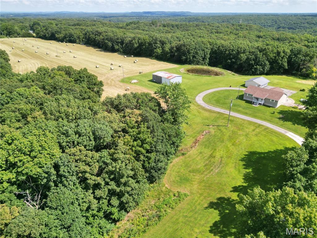 Are you ready to live your dream of homestead living? This secluded gem of 40 Acres m/l is ready for you! You will love the tree lined drive that leads to the secluded home-site just off the blacktop hwy. This modest yet custom home was built in 1993 & includes 1,440 sf on the main floor w/ an additional finished area in the basement. The home has been updated with newer HVAC ('22) & roof ('20). There is also a 3-car detached garage with electric and concrete floor and a metal farm building that is ideal for that "beginning farmer" storage! The property is surrounded by timber and includes a large hay field (6-7 acres m/l). Like to hunt? There are plenty of places to prepare for deer or turkey season! This property also boasts good access to both electric and public water - therefore, it has a lot of potential for additional homes for your friends and family!