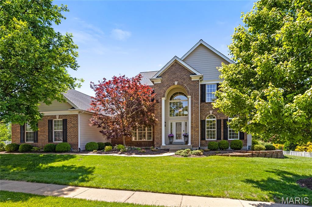 This stately Georgian-style 1.5 Sty blends classic architecture with carefully curated details for a refined living experience. Extensive renovations both inside & out including a custom-designed kitchen & Low-E windows plus Hardie board siding, expanded garage & newer exterior lighting are featured throughout the home. Dramatic porch entrance with architectural columns & wrought iron front door leads to 2-sty hardwood foyer, private study, formal dining room with detailed trim work accents and stunning great room with marble fireplace flanked by 2-sty palladian windows. Vaulted kitchen with granite countertops, 42” bisque cabinetry, premium appliances & crescent center island adjoins light-filled breakfast room with butler’s pantry & atrium door that opens to patio. The primary bedroom suite offers an appealing retreat with extended walk-in closet & luxury bath with glass block shower. T-staircase accesses 3 additional bedrooms, 2 with Jack n’ Jill bath, plus bonus loft room & hall full bath. Lower Level entertainment space includes expansive recreation room, game room, office & full bath. Situated on a professionally landscaped .5-acre lot with stamped concrete patio & 3-car garage. Located in a premier Wildwood neighborhood just minutes from Babler State Park with award-winning Rockwood schools.