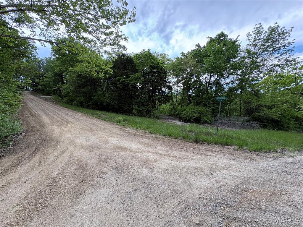 Pinnacle Lake!  Wooded Corner lot close to the main gate and beach. Large, graveled area surrounded by woods ensures your privacy.  Plenty of room for a cabin or camper, firepit, and outdoor living. Wide driveway entrance for easier access. Hop on your SXS and you can be at the beach or boat launch in 60 seconds. Affordable Summertime Fun!  Enjoy the 130-acre community lake that boasts excellent swimming, boating, and fishing. The view of Pinnacle Rock jutting out of the water is nothing short of awe inspiring. There are also miles of community roads to cruise your SXS and get to know the neighbors. Pinnacle Lake is a private, gated community less than an hour from Mid Rivers Mall. Making this a great alternative to some of the larger lake getaways.