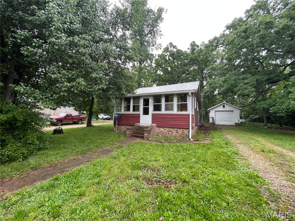 Looking for a mini vacation home or primary residence with a lake view? The enclosed front porch gives you perfect views of the lake. A large sunroom off the kitchen is the perfect place to enjoy your meals. The fenced yard and oversized, detached one-car garage are a huge bonus here. There is plenty of space for a garden on this double lot home. Yard is partially fenced. A stone built-in BBQ is in the rear. The lake boasts great fishing, and the dam has just been rebuilt. There is a beach for swimming, a pavilion for picnics, and swings for playing—all within steps of this great little house. A few updates to this house will make it shine. The basement has a sump pump that may need repair or replacement. The basement is wet. Fireplace appears to be non-functional. More about Iron Mountain Lake: https://ironmountainlake.com/about/.