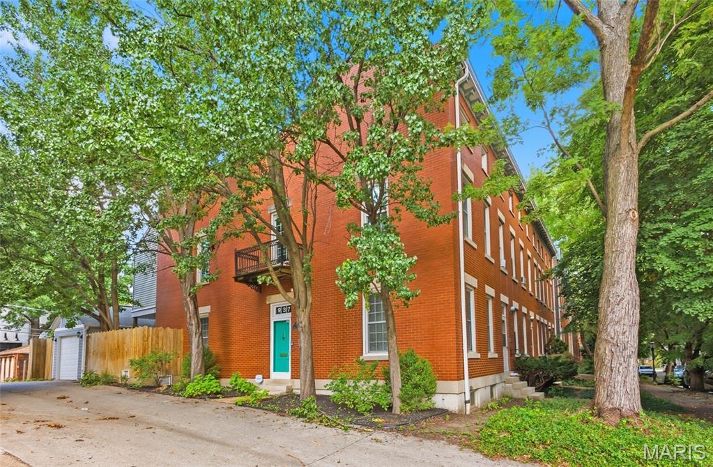 Discover this charming 3-bedroom, 2.5-bath brownstone in the heart of sought-after LaSalle Park. Built in 1983, this home blends modern updates with timeless character, offering hardwood floors, soaring ceilings, and skylights that fill the space with natural light. The inviting living room features built-in bookshelves reminiscent of a Victorian parlor, creating a warm and refined gathering space. The efficient galley kitchen boasts butcher block countertops and ample storage -- the ideal culinary space for the efficient chef, opening to a cozy breakfast area that leads directly to the deck and two detached single-car garages—a rare amenity in this historic neighborhood. The second floor offers a light-filled bedroom and a spacious primary bedroom complete with a bonus room—ideal as a walk-in closet, dressing room, home office, or studio.  The finished lower level is an entertainer’s dream, featuring a binge-worthy theatre/media room with surround sound—perfect for movie nights or hosting watch parties. A stylish wet bar and full bath enhance the space for hosting guests. Outside, enjoy the romance of a gorgeous tree-lined street that provides shade, charm, and ambiance for evening strolls. Close to major highways, Soulard Market, local dining hot spots and our beloved Busch Stadium -- this home offers a vibrant lifestyle in one of St. Louis’ most treasured neighborhoods.