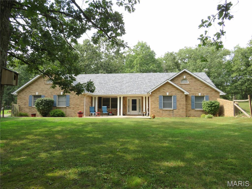 Welcome to this attractive brick-front earth contact home, nestled in a mostly wooded private setting. Lovingly maintained, this 3-bedroom, 2-bath home offers an inviting open floor plan, custom cabinetry, and a spacious primary suite designed for comfort and privacy. The property also features a 2-car garage, 2-car carport, and small storage buildings, providing plenty of room for vehicles, hobbies, and additional storage. Priced below appraised value! If you're looking for a unique home with a peaceful setting and plenty of practical amenities, this one is worth a look!