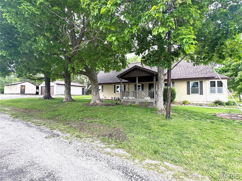 This home, located between Hillsboro and Taylor Springs, has a country feel due to the space between neighbors and the large half acre +/- corner lot. Plenty of outdoor area with many mature trees and ample area for parking of all your toys such as an RV or boat.  Outbuildings consist of a detached 24 x 28 garage, lean-to, 12 x 22 separate workshop, and a fenced-in patio area.  The home with an attached 2 car garage, features two bedrooms and two baths on main floor as well as the living room, dining area, and spacious eat-in kitchen which includes all appliances and built-in window seats perfect for a breakfast nook!  The upstairs is open to be used as third bedroom, family room, play room, or for storage. It has an exit door to an outside upper covered deck with steps to ground level. New hot water heater in 2021.  Most main level windows new in 2021.