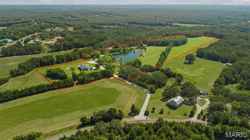 Country Road Take Me Home... to a place where wide-open views, a slower pace & country living awaits. This ranch home features just shy of 2,000 SF, 3 bedrooms, 2 full baths, an office & a bright 3-season room on the main level. Come relax on the covered deck & take in all the scenery. The finished walkout lower level offers a bar, family/rec room, additional sleeping area, 3rd full bath & a full concrete room for storage or storm protection. Step out the front door to one of 3 stocked ponds, grassy meadows & wooded trails giving you ample space to fish, hunt, explore, or simply unwind. In addition to the attached garage is a detached garage/workshop & carport that can accommodate your tractor, equipment & toys. From brilliant fall colors & crisp autumn days to a blanket of winter snow, the fresh awakening of spring & long, lazy summer days...every season has something special to offer. If you are looking for a place where you can breathe a little deeper, spend more time outdoors & enjoy the beauty & rhythm of country living-this place is ready to welcome you home!