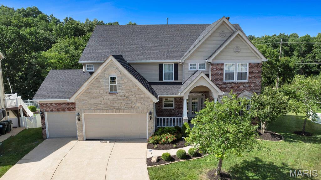 Welcome to this stunning Dickens model in the highly sought-after Strawberry Ridge community, featuring a 5-acre spring-fed lake stocked with fish, a clubhouse, and a community swimming pool. This exceptional home offers 4 spacious bedrooms, 5 bathrooms, and a 3-car garage, combining elegant design with thoughtful upgrades throughout. Inside you will find 9-foot ceilings on the main level, a formal dining room, living room, and private den with French doors. The dramatic two-story great room is filled with natural light from its impressive wall of windows and is anchored by a cozy gas fireplace. The gourmet kitchen and breakfast area showcase ceramic tile flooring, stainless steel appliances, 42-inch maple cabinetry with crown molding, and a charming bay window overlooking the backyard. The windows on the back of the home have been tinted. Upstairs, the luxurious primary suite includes a private balcony overlooking the great room, a spacious walk-in closet, dual vanities, a whirlpool soaking tub, and a separate cultured marble shower. The oversized secondary bedrooms each feature generous size walk-in closets, with a Jack-and-Jill bath serving two bedrooms and a private en-suite bath for the fourth bedroom. The finished walk-out lower level features a 9-foot foundation pour, an exercise room, recreational room, game room/wet bar area and a media room. The refrigerator at the wet bar stays with the home. Some other notable features include built in surround sound speakers and zoned heating and cooling.  Additional highlights include stone and brick front elevation with elegant arched doorways and stone-base columns, wrought-iron staircase spindles with wood stairs and carpet runner, and two 50-gallon water heaters. The roof, some siding and gutters were replaced in 2025. This beautifully appointed home offers the perfect blend of luxury, comfort, and functionality in one of the area's most desirable communities. A truly exceptional property that is ready to impress—schedule your private showing today!