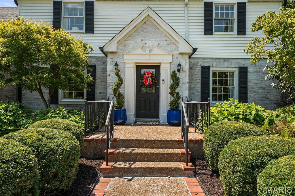 Set on an expansive, beautifully landscaped lot in the sought-after Ladue School District, this gracious home combines classic character with exceptional spaces for everyday living and entertaining. Its central location offers convenient access throughout the St. Louis area, while the mature trees and private backyard create a peaceful retreat at home. The spacious, light-filled dining room features a beautiful gas fireplace, while the inviting living room showcases built-in bookcases and opens to the main-level family room, complete with a second fireplace and access to the lovely patio. The updated kitchen is designed for both everyday living and entertaining, with a charming butler’s pantry, double ovens, built-in Sub Zero refrigerator, beveled subway tile, and gorgeous honed granite and marble countertops. A bright sunroom adjoins the kitchen and provides a seamless connection to the stunning pool and private backyard. The main level also features beautiful wood floors, including herringbone details, two powder rooms, and convenient main-floor laundry. Upstairs, the spacious primary suite includes a beautifully appointed bath with separate vanities and a walk-in closet. Three additional bedrooms and two full baths provide plenty of room for family and guests. The newly remodeled lower level expands the home’s versatility with additional living space plus a full bath: ideal for kids, overnight guests, or extra accommodations during large gatherings. Outside, the expansive, beautifully landscaped lot feels like a private retreat, with mature landscaping, a gorgeous pool set beneath a canopy of mature trees tucked away from the house, and plenty of space for entertaining or simply enjoying the serenity of this special property.