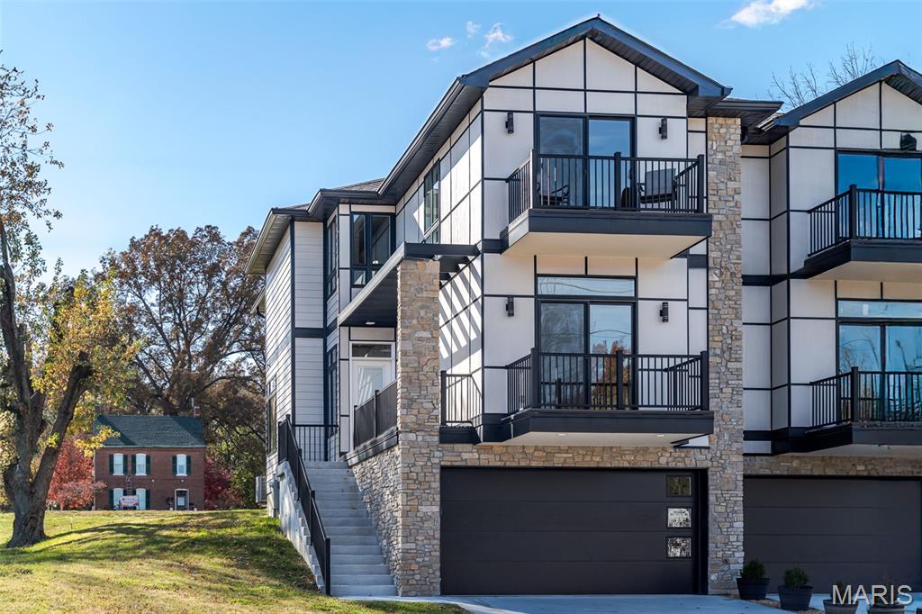 **BRAND NEW PRICE!!!** FREE Luxury sauna and/or Jacuzzi with installation included on any Accepted Contract Signed Before July 10, 2026! CALL for more info!!**  Where warm modern design meets walkable downtown living. This beautifully designed 3 bed, 3.5 bath townhome is tucked into a quiet residential pocket of downtown Washington, just steps from shops, restaurants, the riverfront trail, and year-round events. Offering 2,400+/- sq ft, Missouri River views, two private balconies, and a fenced backyard ideal for pets or play, this home blends luxury with lifestyle.

Designed by architect and structural engineer Peter Conant and Ronnie Romacker, known for large luxury projects nationwide, this residence showcases quality construction and thoughtful design throughout. The open concept main level features top of the line Pergo water- and scratch-resistant flooring, abundant natural light, and a high-end kitchen with granite countertops, premium U.S.–made appliances, a center island, and a bright breakfast nook. The living and dining areas overlook the private fenced backyard and offer direct patio access with a privacy divider. 

The main level also includes a bedroom with private balcony access and a full bath that can function as a private ensuite or guest bath via a pocket door.

Access all levels via a beautiful oak staircase or the residential elevator, servicing every floor and holding up to 1,000 lbs. The upper level features the primary suite with abundant natural light, a walk-in closet with built-ins, and a luxurious ensuite with double vanity, quartz countertops, and a large step-in shower. A cozy river-view nook, an additional ensuite bedroom with private balcony, and an upper-level laundry room with sink and high-end washer and dryer (included) complete this level.

The lower level offers a 2-car garage with epoxy flooring, a half bath, and 570–700 sq ft of partially finished flex space ideal for storage or future living space. Additional highlights include dual HVAC systems, real stone accents, Diamond Kote siding with a 30-year guarantee, and a peaceful yet walkable downtown location. Call to schedule your private showing!