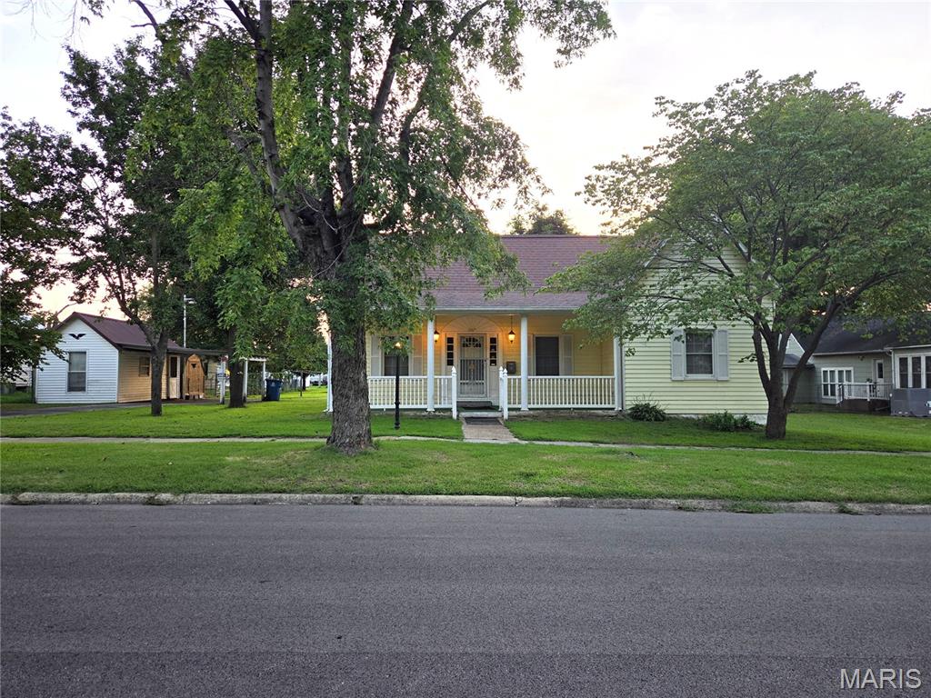 Looking for a home with room to make it your own? This 1920 home offers a practical layout, and plenty of space outside for storage, projects, and hobbies.

The kitchen features a peninsula with additional counter space and room for a casual eating area or breakfast bar. The living room includes a wood-burning fireplace/stove, and the home also has central heat and air. The bathroom features a double vanity for added convenience.

The home does need some work, including flooring and updates to some of the dated finishes, but the exterior has been well maintained. Outside, you'll find a driveway with access to the alley, a detached carport with a small workshop, a storage shed, and an additional larger storage building. There is also a covered front porch where you can sit and enjoy the outdoors.

With three bedrooms, multiple storage and workspace options, central heat and air, and plenty of potential, this home could be a great opportunity for someone looking for a property they can update over time and make their own.