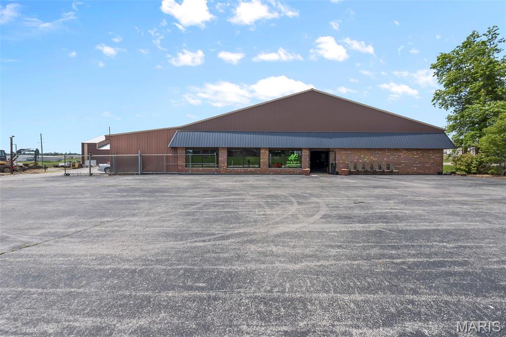 Exceptional commercial opportunity on 1.79 acres of C-2 zoned property featuring two buildings, ample parking, and a versatile layout suited for a variety of business uses. The primary building offers approximately 9,600 sq ft plus a 1,600 sq ft lean-to. Approximately 3,200 sq ft is finished office/showroom space, while the remaining 6,400 sq ft consists of open warehouse/shop space currently used for automotive operations. The showroom features a large service counter, built-in workstations, and oversized double doors allowing vehicle access from the shop area. Additional amenities include an office, vault, parts/storage room, break room, half bath, utility room, security system, and geothermal HVAC. Loops are already installed for a second geothermal unit. The warehouse/shop area features 10-foot ceilings and three overhead doors, including one with a gravel ramp and loading dock beneath. Two additional doors are located under the lean-to, one with a small dock. Three-phase power can be reconnected. The second building, constructed in 2018, measures 50x120 (6,000 sq ft) and includes four 12' x 14' overhead doors plus three open bays ideal for equipment, fleet, RV, or contractor storage. Two enclosed bays are leased at $225/month each and include heat and electric. Additional features include a large asphalt parking lot, fenced yard, corner lot location, and flexibility for automotive, retail, contractor, warehouse, storage, or office use.