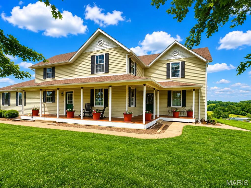 If you've been dreaming of that quiet country home with a wraparound porch and memorable sunrises and sunsets you will want to stop and look at this beautiful home just outside of New Haven, MO.  Motivated sellers have this beautiful countryside New Haven, MO property priced WAY below a recent appraisal!
Experience the timeless charm of country living with this stunning 5-bedroom, 2.5-bath farmhouse situated on 3.55 picturesque acres with breathtaking panoramic views stretching for miles. Combining classic character with modern updates, this spacious home offers the perfect blend of comfort, functionality, and rural beauty. 

Step inside to discover custom original woodwork throughout, showcasing craftsmanship rarely found today. The inviting main level features both a large family room and separate living room, a formal dining room accented with crown molding, and a beautifully designed island kitchen perfect for gathering with family and friends. A cozy gas fireplace creates a warm and welcoming atmosphere, while the convenience of both main-floor and second-floor laundry makes everyday living a breeze.

The main-level primary suite serves as a private retreat with a whirlpool tub, oversized walk-in closet, and plenty of space to unwind. Upstairs, you'll find four additional bedrooms and a full bath, providing ample space for family and guests. Original wainscot ceilings add character and charm throughout the upper level, preserving the home's authentic farmhouse appeal.

Outside, you'll fall in love with the iconic wraparound porch—an ideal place to enjoy morning coffee, evening sunsets, and some of the most spectacular countryside views imaginable. The property also features an oversized side-entry two-car garage, multiple outbuildings, an original grain bin, and an above-ground pool, offering endless opportunities for hobbies, storage, recreation, or small-scale homesteading.

Recent improvements include a newer roof, HVAC system, and water heater, providing peace of mind for years to come.

 Located just 2 miles from New Haven, 12 miles from Washington, and 12 miles from Hermann, this country home offers the convenient location you have been looking for in an excellent school district! 

Whether you're looking for a private country retreat, a place to raise a family, or simply room to breathe and enjoy the beauty of rural living, this exceptional property delivers the farmhouse lifestyle you've been dreaming of.  Contact us TODAY for more information!