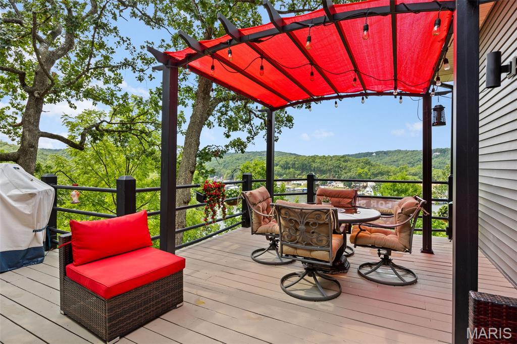 Discover this immaculate 2nd-tier ranch in Linn Creek, boasting spectacular panoramic views of the 29.5 MM. Far from a "cookie-cutter" home, this 3-bedroom, 3-bathroom residence is bursting with style, character, and extensive high-end updates inside and out. The exterior features a newer roof with leaf guards, newer siding, windows, and a fresh concrete driveway. Relax on the deck under a beautiful pergola or enjoy the professionally landscaped yard with a sprinkler system and a fenced dog run. Inside, the home shines with quartz countertops, custom cabinetry, new appliances, fresh flooring and paint throughout. All three bathrooms have been gutted and remodeled, including a luxury master en-suite with a new soaker tub and custom walk-in shower. For ultimate comfort, the master suite includes its own dedicated furnace and water heater. Cozy up to the wood-burning fireplace in the winter or enjoy lake views from the master and living areas year-round. Modern mechanicals include a new heat pump and water softener. With a 2-car garage, extensive parking for guests or toys, NO HOA, & rentals allowed, this move-in-ready gem offers total freedom. Your perfect lake-view lifestyle awaits!