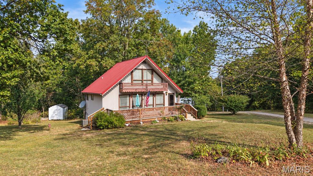 Lake life, a charming A-frame, and a gated lake community! What more could you ask for? Welcome to this adorable 2-bedroom, 1 bathroom A-frame home located in the gated community of Lake Timberline in Bonne Terre, Missouri. Situated on a large corner lot with a nice flat yard, this home offers the perfect opportunity to enjoy the lake lifestyle, whether you're looking for a full-time home, a weekend getaway, or a place to escape and enjoy the amenities. Lake Timberline is a gated community featuring 10 plus lakes, three beach access points, a clubhouse, a playground and more. Inside you'll find a comfortable main level living space with an open floor plan. The main floor includes one bedroom and one full bath, along with a nice size living room that flows into the dining area and kitchen. The refrigerator stays, and the washer and dryer stay with the home as well, conveniently located on the main level. Head upstairs to the finished attic where you'll find the second bedroom. Outside, enjoy the back deck, a great spot to relax and take in the peaceful surroundings. The two car carport provides convenient covered parking, while two storage sheds offer additional space for outdoor equipment, lake toys, and storage needs. The property does need some TLC and is being sold as is, providing the opportunity to make improvements according to your own style and preferences. Bring your vision, make it your own and start enjoying the Lake Timberline lifestyle in Bonne Terre.