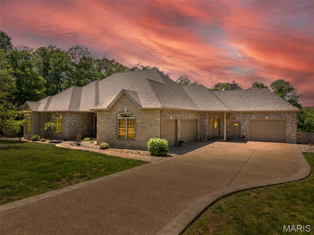 LOCATION is perfection! Travel down a paved road and arrive at your custom ranch home, with double garages, a finished basement, stunning seller/builder details with over 5,000 total finished SF! I need way more space here to describe all of the features. Large kitchen with second dining / living area arranged around the Buck stove fireplace. Brazilian cherry flooring, double wall ovens, long peninsula and island, custom cabinets and tile backsplash. Seller just had a new refrigerator installed in March of 2026.  Living room has 12 foot coffered ceilings, Hickory flooring, a second stone fireplace surround, with a 3 season room to enjoy the scenery. Open dining room connects fully to the living room. On the main floor there are 3 bedrooms, an office, and 2.5 baths. Main floor laundry is just off garage entry area. The primary bedroom features an ensuite that is fully custom with a tiled shower, double showerheads, a soaking tub, and walk-in closet. The other 2 bedrooms are connected with a generous Jack in Jill bathroom. Office has large window overlooking backyard and double doors on the entrance. The lower level is unlike any basement you have ever seen! Wine room, bar, movie viewing area, sleeping area and 3rd full bathroom. There is a workout area and unfinished space for storage. The basement level walks out to the deck, enjoy the privacy and woods that back to this property. You have 3+ acres, plenty of room here! Landscaping and custom stamped and exposed aggregate concrete round out this beautiful property, must see in person to fully appreciate it! Located in the heart of Defiance, MO Wine country and biking and region. Please schedule a showing to see this splended home in person!