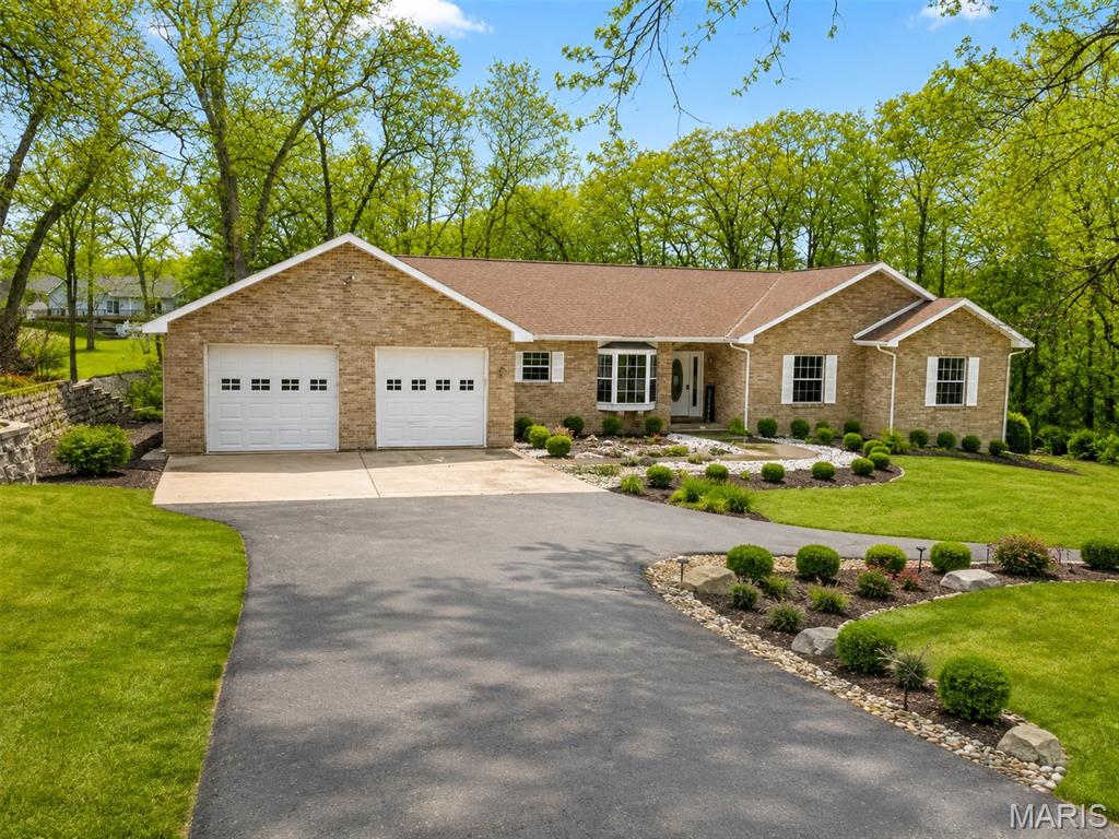 Lake living with room for everyone! This spacious 4-bedroom, 3-bath home offers approximately 3,600 sq. ft. of living space and is beautifully situated on just over an acre with lake access and a private one-slip boat dock with a deck and covered boathouse.

The main level features a spacious, open layout designed for both everyday living and entertaining. The kitchen flows into the main living areas, while patio doors from the living room lead directly to the expansive deck overlooking the property and lake access. The primary suite also offers its own patio doors to the deck, creating a wonderful place to enjoy the peaceful setting. A convenient main-level laundry room adds to the home's functionality.

The walkout lower level is like a second home of its own, making it ideal for extended family, guests, or multi-generational living. It includes a living room, dining area, kitchen, huge bedroom, full bathroom, separate laundry, and two additional bonus rooms. Patio doors open to the lower-level patio and backyard, providing easy access to the lake and outdoor entertaining areas.

Outside, enjoy the upper deck with views toward the lake, lower patio, beautiful yard, private boat dock and boathouse, plus an impressive 4-car garage offering plenty of space for vehicles, lake toys, storage, and more.

With over an acre, approximately 3,600 sq. ft., two separate living areas, multiple outdoor spaces, a 4-car garage, and your own boat slip, this home offers an incredible combination of space, flexibility, and lake lifestyle.