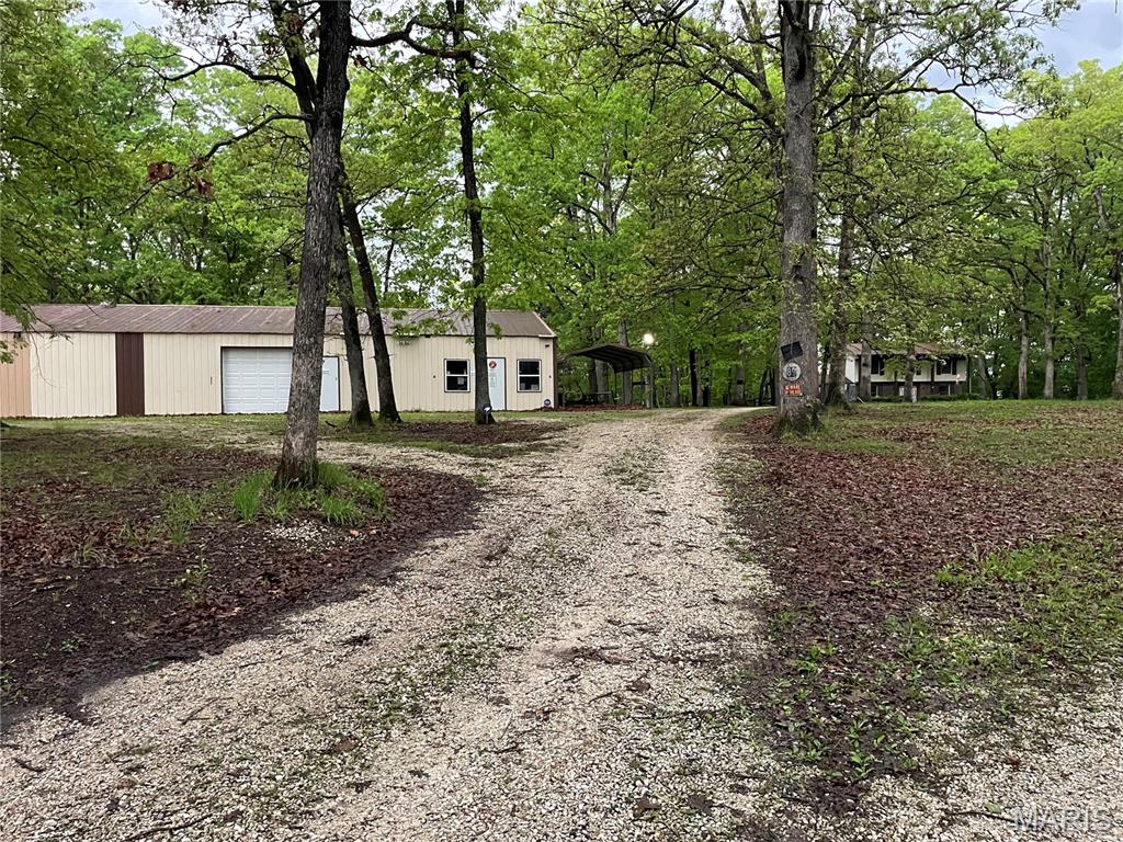 Escape to approximately 60 acres of rolling, fully wooded terrain offering exceptional recreational value, privacy, and investment potential. This remarkable property features heavy woods, suitable for riding trails and pond sites, a dedicated shooting range, and abundant wildlife, making it an ideal retreat for hunters, outdoor enthusiasts, or those seeking a secluded getaway.

Enhancing the property's versatility is a two-story residence offering 3 bedrooms and 2 bathrooms with a brick front and vinyl exterior. The home includes an attached one-car garage. Home is being sold in as-is condition.

A standout feature is the impressive 40' x 80' climate-controlled metal outbuilding, complete with two overhead doors and two service doors, perfectly suited for equipment storage, a professional workshop, hobby space, or an ultimate gathering place after a day in the woods.

Whether you're searching for a private hunting preserve, weekend retreat, future homestead, or long-term land investment, this unique property offers endless opportunities.
