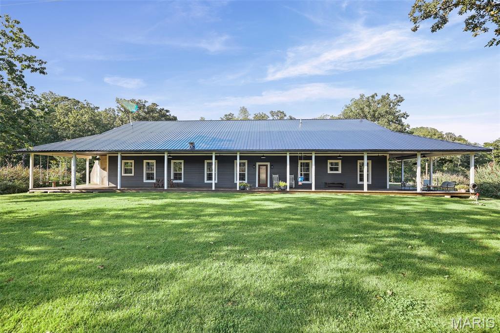 Escape to your own private retreat with this beautiful 4-bedroom, 3-bath home situated on just over 10 acres in a peaceful rural setting. Offering approximately 2,400 square feet of living space, an attached 2-car garage, pole barn, wooded acreage, and a beautiful lake, this property combines comfortable living with an incredible outdoor setting.
Built in 2009, the home features durable concrete wall and roof construction and a spacious open floor plan connecting the living room, dining area, and kitchen—perfect for everyday living and entertaining. The kitchen features granite countertops, a center island, and plenty of room to gather. The covered wrap around porch offers plenty of space for enjoying the setting. The full concrete construction offers the energy efficiencies people are looking for. The new roof and updated color make it inviting to arrive home. 
The primary suite is thoughtfully separated from the additional bedrooms for added privacy. This spacious retreat includes its own office, walk-in closet, and private bath with a large soaking tub and separate shower. A second office provides even more flexibility for working from home, hobbies, or additional workspace.
The wooded acreage surrounds a beautiful lake, creating a waterfront setting that feels tucked away from it all. A dock offers the perfect spot for fishing, launching a kayak, or simply relaxing by the water.
Enjoy quiet mornings, peaceful evenings, and unforgettable sunsets from the large covered wraparound porch. With more than 10 acres to explore, mature woods, waterfront access, an additional pole barn with concrete floors, and plenty of room to enjoy the outdoors, this property offers the kind of peaceful country lifestyle that is increasingly hard to find.
The fixed interest rate may be assignable to the right buyer.