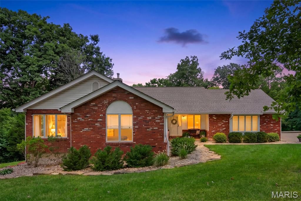 Set on 9.5 wooded acres, this meticulously maintained 4 bedroom, 4 bath ranch offers the kind of privacy and quiet that is getting harder to find. No traffic noise, no neighbors looking in, just mature timber, rolling terrain and fabulous views in every season. The property even has its own waterfall.
Inside, the spacious great room features a vaulted ceiling, skylights and a wall of windows that fill the space with natural light and pull the views inside. A large brick fireplace with wood burning insert anchors the room. The kitchen offers abundant cabinetry, a planning desk and a dining area, with main floor laundry close by for easy one level living. The vaulted primary suite includes a walk in closet and a private bath with double sink vanity, jetted tub and separate shower. Two additional bedrooms are on the main level, one with its own private bath, and both have been updated.
The finished walk out lower level is a true extension of the living space, with luxury vinyl wood flooring, a 4th bedroom, a 4th full bath and a large recreation area that is great for entertaining. Lots of windows and natural light throughout, plus space that offers the potential for a 5th bedroom. A ramp from the garage down to the lower level makes it easy to move four wheelers, lawn tractors and equipment in and out.
Outside, a maintenance free composite deck is the place to take it all in, whether that is morning coffee with the woods to yourself or evenings listening to nothing but nature. Ultimate privacy, and still an easy drive to Hwy 40.