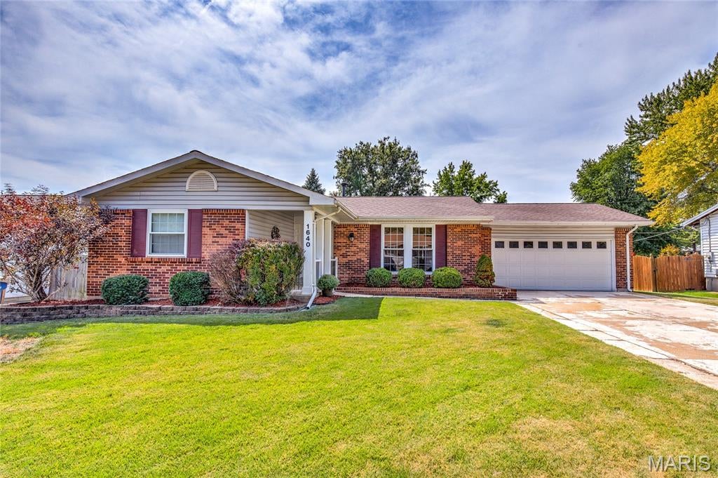Fine living in Florissant - sprawling ranch with upscale neutral finishes, STUNNING KITCHEN, part-finished lower level and fenced backyard. WALKABLE to pocket park, Walgreens, preschool and 40-acre KOCH PARK (newer pool complex, playgrounds, sports). Timeless curb appeal with BRICK FRONT, vinyl siding/soffit/fascia, COVERED PORCH, easy-care landscaping, 2-car garage, plus expanded double driveway. Entry foyer opens to bright living room with HARDWOOD FLOORS and breezy ceiling fan. Incredible custom kitchen with to-ceiling raised-panel cabinets with crown in WARM WOOD finish, GRANITE COUNTERS, stone tile backsplash and diagonal-laid ceramic tile floors. Chef's stainless appliances include DOUBLE WALL OVEN, gas cooktop with countertop controls, vent hood and dishwasher. Adjacent dining room with sliding door to OVERSIZED PATIO - ideal for entertaining. 3 spacious bedrooms with hardwood flooring and ceiling fans. Bonus walk-in hall closet! UPDATED BATHS with custom tile - first with tub/shower combo, second with step-in shower. Downstairs partially finished with HUGE FLEXIBLE REC ROOM, plus laundry and storage. Nearby pocket park at Fernwood Trail features playground, pickleball and tennis. SUPER CONVENIENT location near Hwy 270, with most daily errands within a mile.