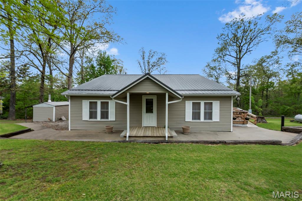 Country living at its finest has arrived with this beautifully remodeled home offering over 1,800 sq ft of warmth and character. Inside, you'll be drawn to the charm of tongue and groove walls and ceilings that create a cozy, inviting atmosphere throughout several rooms. The primary suite is thoughtfully designed with double closets, a built-in storage bench, and convenient access to the laundry room. The spacious living room serves as the heart of the home, perfect for gathering, while the kitchen features stunning cabinetry, quartz countertops, and easy flow into the separate dining area. Step outside and enjoy peaceful wooded views from the lower patio--already wired for hot tub, making it the perfect spot to relax and unwind. The walk-out basement offers additional storage and includes a built-in safe for added peace of mind. Multiple heating options, including an outdoor wood furnace, propane, and electric, provide both flexibility and efficiency. The standout feature of this property is the impressive 30x50 insulated shop with a 14x32 and 12x14 additions. With three garage bays, including two 10' doors for boat or camper storage, you can easily park 5 vehicles. This space is ready for projects, storage, or hobbies. Equipped with electric, a 10,000 lb car lift, ceiling fans, fluorescent lighting, toilet, sink, and openers, it's truly a dream setup. A generous overhang creates an ideal space for entertaining or relaxing outdoors. Additional features include a garden shed, raised flower beds, and a property that has been exceptionally well maintained inside and out. If you've been searching for comfort, functionality, and space to enjoy the outdoors, this one is a must-see.