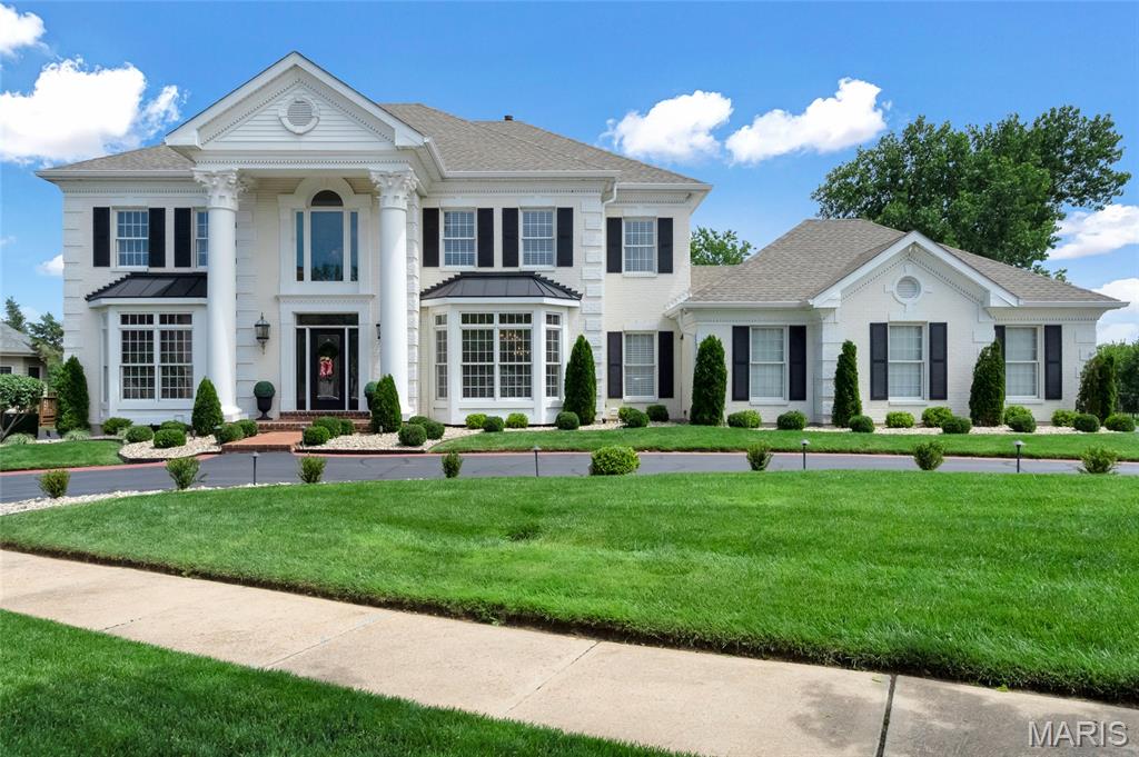 Experience refined living in this stately 5 bedroom, 4 full/2 half bath residence offering over 5,700 sq. ft. of luxurious space, nestled on a private 0.4 acre lot. From the moment you arrive, the circular drive, brick exterior and grand pillars create an elegant first impression. Enter through the two story foyer, where you’re greeted by a grand dual staircase. Framing the foyer, an elegant formal dining room and a distinguished home office. Generous living room with gas fireplace, window wall, custom built ins and wet bar—ideal for entertaining. Gourmet kitchen features SS appliances, double ovens, oversized island with breakfast bar and adjoining breakfast room. Inviting sunroom offers abundant natural light, while a main floor laundry and two half baths add convenience. Upstairs, the generous primary suite is a true retreat with hardwood floors, coffered ceiling and a spa inspired ensuite featuring a soaking tub, custom shower, dual vanities and walk-in closet. Ensuite bedroom and two addl. bedrooms with shared bath upstairs. Lower level is ideal for guests and offers a second kitchen, family room with fireplace, rec. area, bedroom, full bath and bonus room. Walk out to the covered patio. Every detail, from moldings to custom finishes, reflects thoughtful design. Impressive outdoor living with a substantial deck and a pergola covered patio, with steps leading to an expansive heated pool with gazebo, beautifully set within lush landscaping. Convenient access to Hwy 40. Extensive updates list.