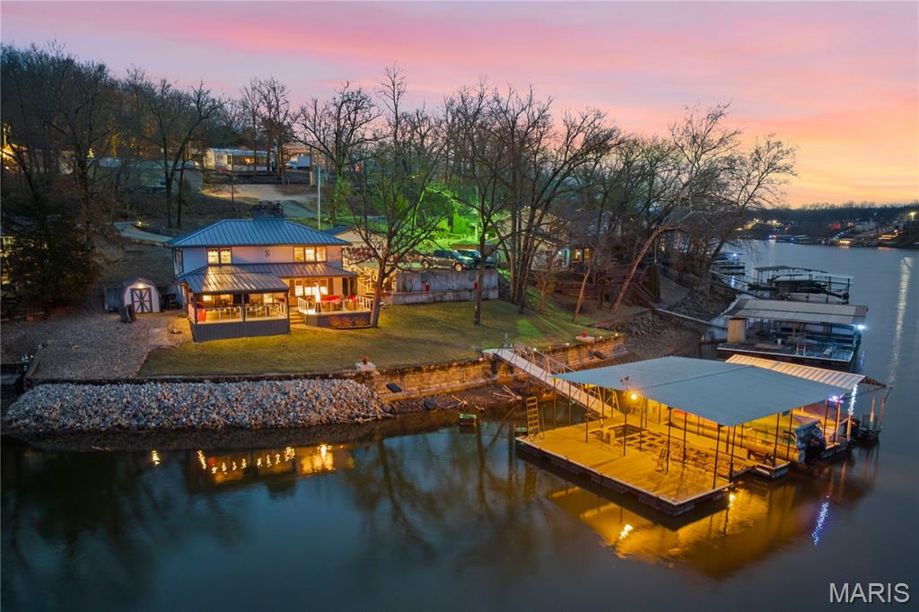 Escape to the ultimate no-wake cove sanctuary at 39MM in Sunrise Beach where Luxury Meets Peace of Mind. This exquisitely cared for 4BR/2BA ranch-style lakefront home is a masterclass in comfort & investment potential, perfectly positioned to capture breathtaking, sunset views every evening. No detail has been overlooked in this high-end renovation. New metal roof, energy-efficient windows, a modern heat-pump HVAC, & a high-tech water softener. Step onto the premium Envision decking—complete with integrated LED lighting—& experience 140’ of shoreline on a gentle, beautifully landscaped lot. Equipped with a Boater’s Setup: 3-Well Private Dock: (12x30, 12x25, 10x20) featuring a 12,000-lb lift & updated dock electric, Easy Access: A cabled walkway leads you to the year-round deep water; Bonus Space: Includes a detached 2-car garage, massive concrete driveway, & a bonus 1/4-acre second-tier lot for future expansion or extra parking. Inside, the easy-flow floor plan features 2 cozy wood-burning fireplaces, perfect for chilly nights. With concrete retaining walls, established gardens, & a lakeside firepit, this is a rare, turnkey opportunity! Don't wait—your sunset retreat is calling!
