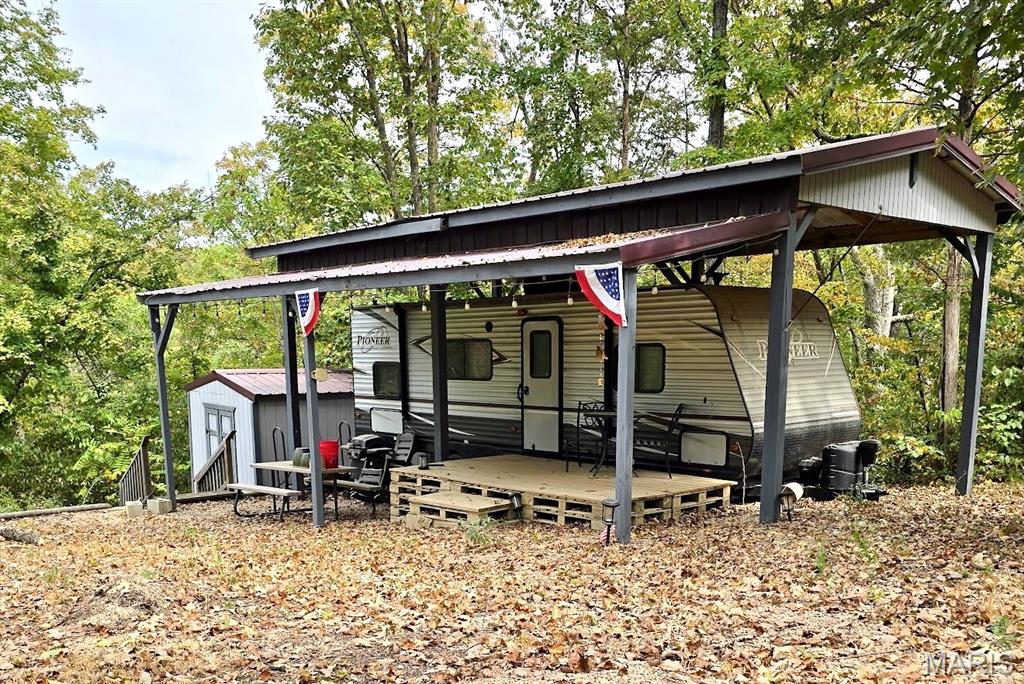 Fully setup and ready for your camping and fishing adventures. *Extra Bonus* This years Dues are paid in full!!! Half acre waterfront camping lot on Cedar Lake. 2017 Pioneer 28 foot bunk house camper, kept under permanent RV carport. Private 220 amp electric service on property, along with 200 gallon above ground water tank and 100 gallon above ground septic tank. Gravel section on lot can be used for parking or entertaining. Seller has installed retaining wall, fire pit, and a path to the water's edge. 12x12 storage shed has electricity, interior shelving and work bench. Enjoy fishing and relaxing on this recreational lot. Located in a gated community. Additional Rooms: In Platted Subdv.