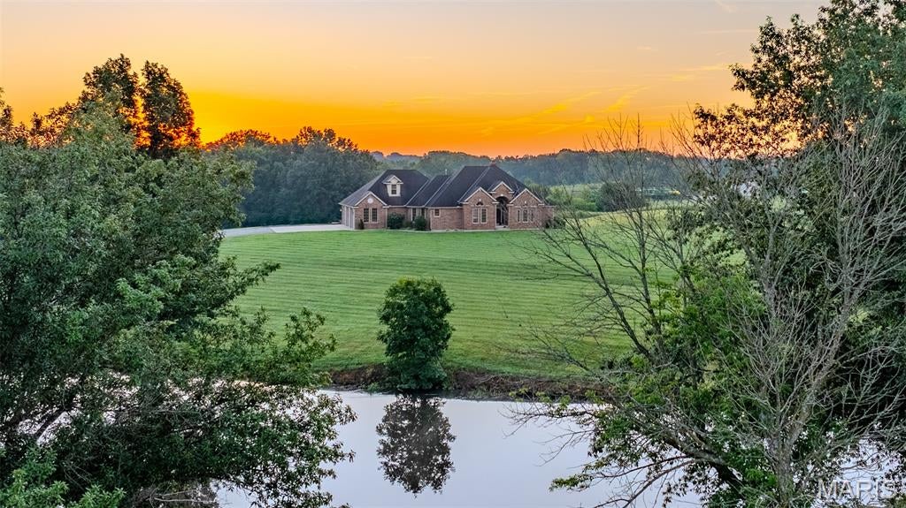 Situated in Ray County, Missouri, this distinguished property at 9791 Leathers Road in Richmond offers a refined rural living opportunity. The well-appointed residence, constructed in 1997, spans 2600 square feet and features six bedrooms and three and a half bathrooms, providing ample space for comfortable living. The home boasts modern comforts including granite countertops, two fireplaces, and a finished basement, enhancing its appeal and functionality. A primary suite with a walk-in closet adds to the thoughtful design, complemented by a three-car garage for vehicles and storage.

Beyond the residence, the property encompasses 7.24 pasture acres, presenting options for livestock, recreation, or simply enjoying open space. A private stocked pond serves as a notable water feature, enhancing the natural landscape which ranges from level to gently rolling topography. Practical improvements include a 30x40 shed, ideal for equipment storage or workshop needs. Essential utilities such as electric, septic, and water are already established on site, with convenient access provided by a gravel road, ensuring both privacy and functionality. With small town living and the convenience of being just minutes from the highway, this property offers the best of both worlds. Hop on highway 210 and you're only 33 miles from North Kansas City, making your commute to the city quick and easy.