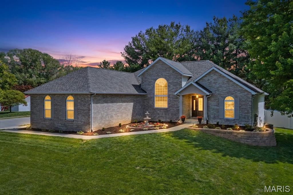 Welcome to 2654 Meridian Lake Dr — a beautifully updated one-level ranch in Shiloh's High Valley Lake Estates, freshly refreshed and truly move-in ready. From the manicured corner lot, stone retaining walls, and tiered garden fountain to the columned portico entry, the curb appeal welcomes you the moment you arrive. Inside, a sought-after split-bedroom plan gives the primary suite its own private wing, while vaulted ceilings and large windows fill the open living space with natural light around a cozy gas-log fireplace with a raised hearth. Integrated surround sound carries through the living room, primary suite, and finished lower level. Hand-scraped hickory floors lead into a remodeled kitchen with soft-close custom cabinetry, a breakfast bar, Cambria quartz counters, a subway-tile backsplash, and a full stainless suite. Off the sunny breakfast room, sliding doors open to a low-maintenance composite deck, brick-paver patio, and a vinyl privacy-fenced yard backing to mature trees. The primary suite features a tray ceiling, custom wainscoting, a walk-in closet with a Freedom Rail system, and a five-piece bath with double vanity, separate shower, and deep soaking tub. Two more main-level bedrooms sit beside the second full bath, and a main-level laundry/mudroom off the garage keeps things organized. Downstairs, 977 square feet of finished living space delivers a rec room set up for a projector home theater, a third full bath, and a custom wet bar with espresso cabinetry, a wine rack, and a full-size refrigerator. The updates are done and receipts are on file — plus a security system, a radon mitigation system, a roof only about a year old, and a side-entry 2-car garage. Minutes to Scott AFB, I-64, shopping, dining, and Memorial Hospital East, and within Whiteside School District 115. No HOA — just move in.