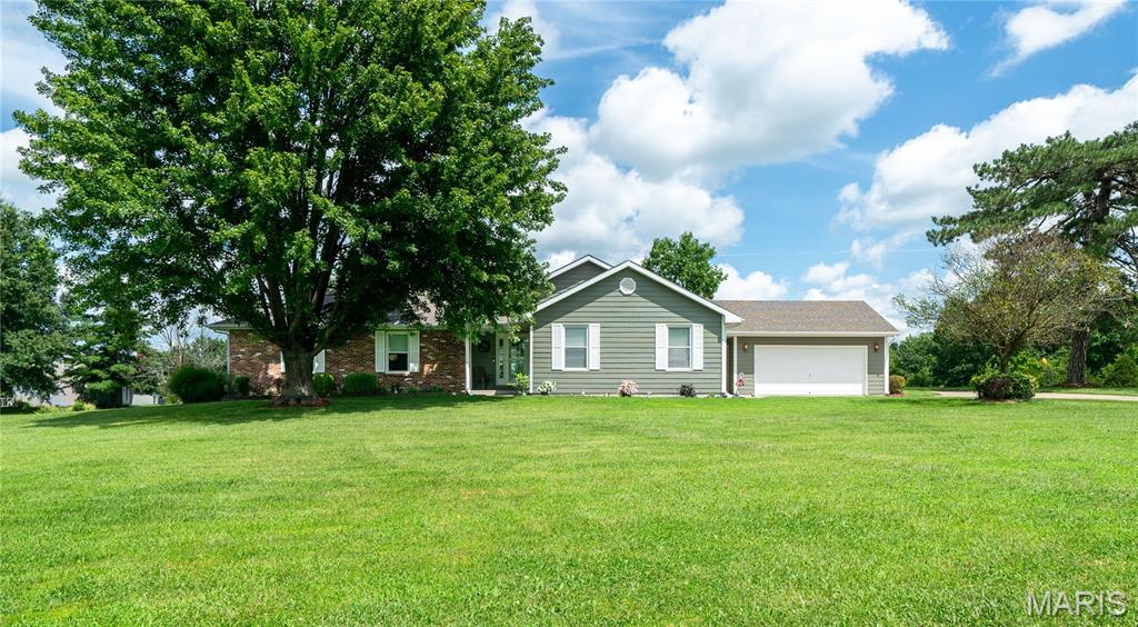 Enjoy comfortable one-level living on 2.5 beautifully maintained acres in the Hallsville School District and just a quick commute to Columbia. This well-cared-for 3 bedroom, 2 bath home welcomes you with an inviting entryway and a spacious living room featuring a cozy gas fireplace. The kitchen has granite countertops and freshly painted cabinetry. Outside, a large composite deck overlooks the beautifully landscaped yard, creating the perfect setting for relaxing or entertaining. Brick and concrete fiberboard siding provide lasting curb appeal, while updated heating and cooling and a newer roof offer added peace of mind. The property also features additional parking and two separate two-car garages, providing exceptional storage and workspace options.