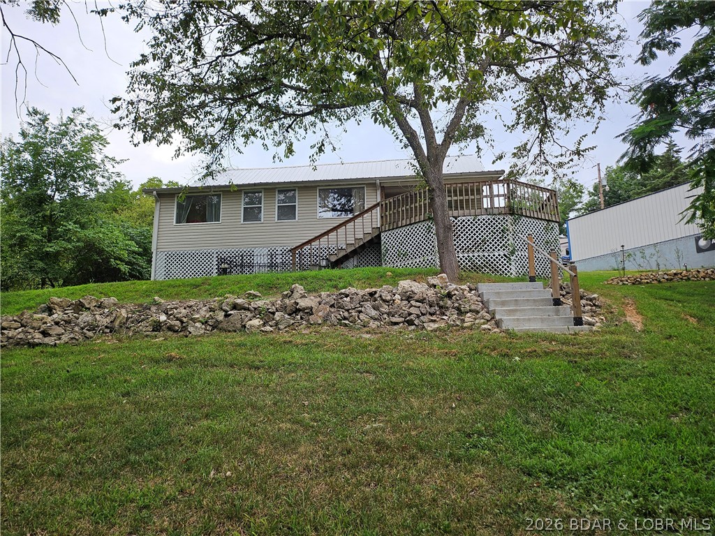 Motivated Seller!!! Turnkey move-in ready property is your start to enjoying the Lake! Kid friendly lakefront. Great place for kids to play in the water or adults to just float & relax their cares away. Perfect location for a pontoon at the 66 mile marker in quieter waters.  4 bedrooms (2 on each level) and 2 full baths (1 on each level), plenty of room for family and/or friends. The huge bedroom on the upper level has several beds (bunkhouse style) would certainly be enjoyed by the kids. They probably wouldn't get any sleep! What memories could be made here! Large lakeside deck for a lake view with a covered section to enjoy even in the rain. If you want some extra income, would make a great rental place. Property is only about half a mile from Holiday Mills Marina and store. Gas up your boat and get last minute items you forgot. The gently sloping yard leads to a 1-well covered dock with a swim platform.  Updates: Central A/C - 4yrs old, new water heater in 2022, whole new septic system in 2021, leaf guard guttering in 2019, roadside roof replaced in 2021, new survey for left property line. 1-car attached garage with kitchen entry.