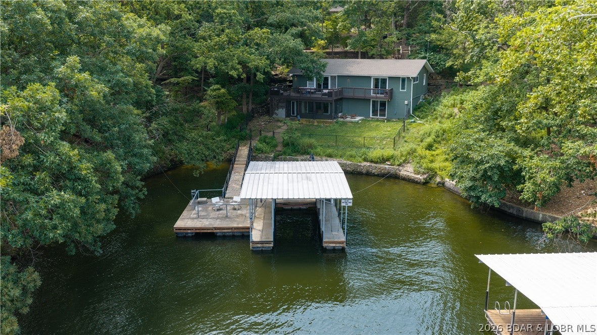 Opportunities like this don't come around often. Located at the 22 Mile Marker in the heart of Osage Beach, this fully furnished 5-bedroom, 3-bath lakefront home offers over 2,700 square feet of updated living space, 120 feet of gentle shoreline, and a massive concrete dock with year-round water. Over $130,000 has been invested in recent improvements, including a brand-new well and septic system, making this property truly move-in ready. Looking for an investment? This home has averaged approximately $121,000 in gross rental income annually over the past two years. Outside, you'll find a fenced backyard and plenty of parking, while the garage has been converted into a spacious game room that's perfect for entertaining family and friends. Relax on the sunporch, gather around the cozy brick fireplace, or spend the day on the water while enjoying peaceful cove protection with beautiful lake views. Whether you're searching for a luxury vacation home, full-time residence, or proven income-producing property, this one has it all.