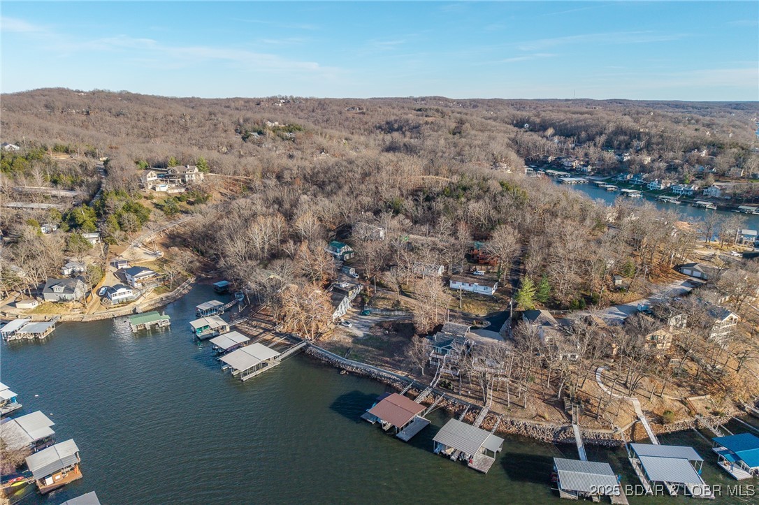 Rare Double Lakefront Lot in Highly Desirable Linn Creek Cove! Opportunities like this don’t come around often! This exceptional double lakefront lot offers 137 feet of pristine waterfront in a deep-water cove with excellent protection—while still capturing beautiful main channel views of the Four Corners. The perfect combination of privacy, scenery, and premium lake access. All the hard work has already been done for you. This property includes: New seawall and riprap for long-term shoreline security,  engineered septic system configuration, current survey, house plans and dock plans already completed with room for a large dock thanks to generous water frontage and deep water. Whether you’re envisioning a luxury retreat or a full-time lakefront dream home, this rare offering provides a true “build-ready” experience in one of the most sought-after areas at Lake of the Ozarks. Bring your builder and start making your lake life vision a reality!