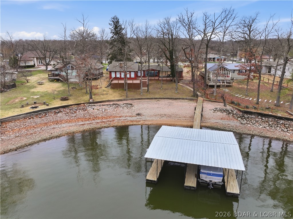 Rare opportunity to own a flat, step-free lakefront lot in the heart of Osage Beach with stunning main channel bluff views. This unique property offers a true swim beach and private dock, creating the ideal setting for enjoying lakefront living with unmatched convenience by both land and water. The home features 3 bedrooms and 2 bathrooms, offering a charming and functional layout that is move-in ready for the summer season. Whether you choose to enjoy it as-is or update and expand, the large lot provides ample space to build, renovate, or create a custom lakefront retreat tailored to your vision. Properties with this combination of a gentle lot, direct water access, and prime location are exceptionally rare. Having been held in the same family for over 50 years, this property presents a unique opportunity to establish your own legacy at the Lake of the Ozarks. Endless potential, unbeatable location, and immediate usability—this is lake living at its finest.