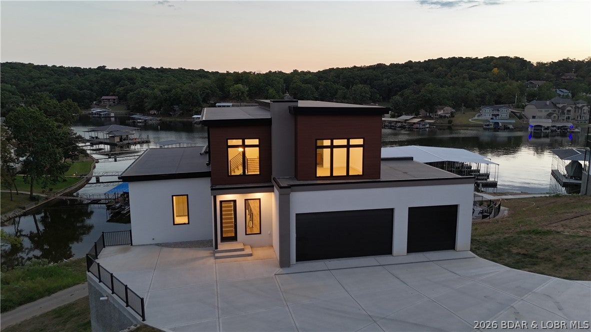 Experience brand-new lakefront living at The Cove! This impressive 6-bedroom, 5.5-bath home offers 5,463 sq ft of beautifully designed living space with the room and setting to create an incredible Lake of the Ozarks retreat. Spacious gathering areas, beautiful lake views and multiple covered outdoor living spaces make this home perfect for entertaining family and friends or simply relaxing by the water. Thoughtful finishes throughout include custom cabinetry, quartz and granite countertops, stainless steel appliances and beautifully finished bedrooms and baths. The Cove also offers a community pool and community dock, with boat slips available for purchase. Located off Bittersweet Road in Lake Ozark, you’re just minutes from Shady Gators, waterfront dining, boating and some of the lake’s most popular destinations. With over 5,400 sq ft and true lakefront living, this is an incredible opportunity to enjoy the lake in a brand-new home.