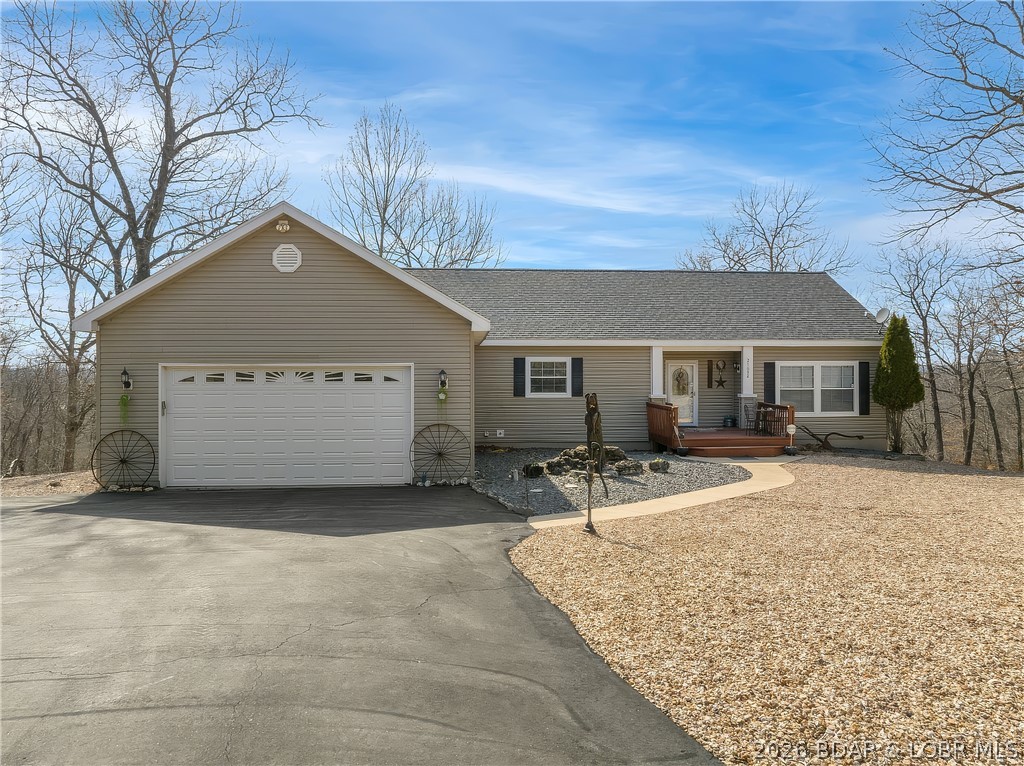 Unique country home with impressive lake views on 9.7 acres & a community dock slip! An inviting front porch welcomes you into an open living, kitchen, and dining area with 9-foot ceilings, wood-burning fireplace, and access to a large lakeview deck. The kitchen features an island, breakfast bar, custom oak cabinetry, walk-in pantry, and built-in china cabinet. The main-level master suite offers a jetted tub, walk-in shower, and spacious walk-in closet. Downstairs opens into an expansive entertainment level designed for "Happy Hour". This cavernous space includes a game area, pool table, and TV/lounge area. A custom rustic cedar bar creates a true centerpiece with sink, stove, cabinetry, and refrigerators. The lower level also includes a bedroom, a large bathroom with double sinks and a custom walk-in shower, plus generous storage space and walk-out access. Additional features include an attached 2-car garage, picnic area, and attractive landscaping. The property includes an 11x28 slip in the community dock along with a convenient boat ramp. Excellent lake location close to popular waterfront destinations, including Coconuts at the Lake and enjoy Jolly Rogers by land or water.