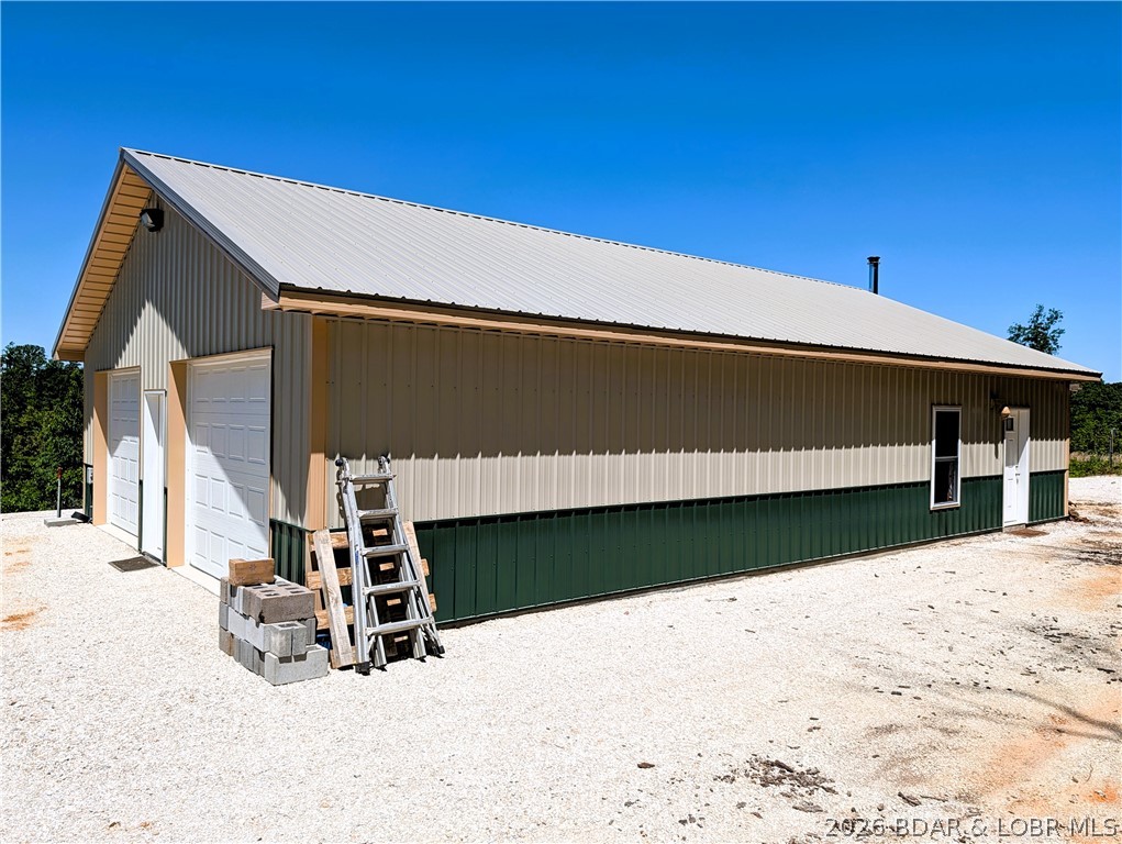 45.4  ACRES & Newer 32 ft x 50 ft  metal building built on a full slab concrete floor. 704 sq ft of partially finished living space studded walls, 1 bedroom & 1 full bath also living room, dining, kitchen features industrial deep well double kitchen sink, SS refrigerator, Janska 36" commercial freestanding gas over electric stove, New  washer and dryer & water softener. Lots of windows to enjoy the wildlife and space surrounds by 45.4 wooded  surveyed acreage with lots of road frontage. You will find a 2 car oversize 32x28 attached garage. features 10 ft door and a 11 ft door with 2 openers.   The interior is just waiting for your finishing touches. Walls and ceiling have sprayed insulation.  Heating the home is easy with the Englander Blue Ridge 500 top of the line wood stove.   Mini split just waiting to be hooked up. CO-MO  fiber internet. Other features framed 3 ft doors easy level access, 2x6 walls with a  9 ft ceiling height. Drilled well and septic/lagoon.  Security  light and camera.  Montana Rd is a dead end road. The land is perfect for a recreational retreat features mixed terrain for making trails in the outdoors. Near a Lake Access at the 10 mm Gravois Mills.
