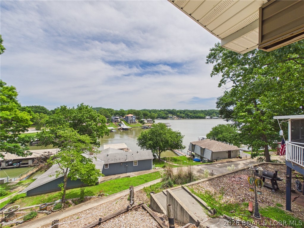 Enjoy lake living in this beautifully updated second-tier home with views of the cove and main channel. Located just off Highway 5, this 2-bed, 2-bath retreat offers easy access to everything at the Lake of the Ozarks. The home is bright and airy with abundant windows and major upgrades already completed, including roof, gutters, composite decking, HVAC, water heater, and water softener—making it truly move-in ready. A short walk takes you to the community dock with a swim platform and a spacious outdoor gathering area perfect for entertaining. This property includes a boat slip, boat lift, and dock box, giving you everything you need for effortless days on the water. Additional storage comes from a generous utility shed and a garage ideal for a golf cart and lake toys. Whether you're seeking a full-time home, weekend getaway, or investment opportunity, this property delivers convenience, updates, and the lake lifestyle buyers love.