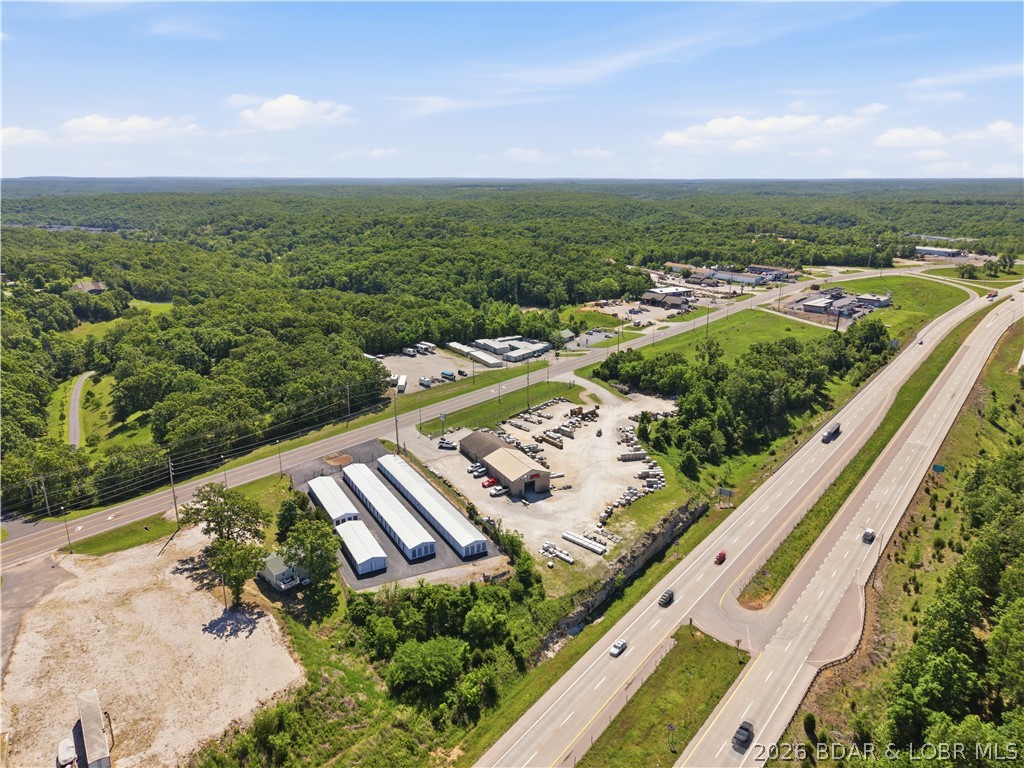 Positioned in a prime location on Osage Beach Parkway, this exceptional commercial property offers outstanding visibility with approximately 417 feet of highway frontage and strong daily traffic exposure. Sitting on over 2 acres, the property presents endless potential for investors, developers, or business owners looking to capitalize on one of the lake area’s most traveled corridors. Nearly half of the property has already been cleared, providing a fantastic opportunity to build, expand, or create the commercial space you've envisioned. Whether you're considering retail, office space, service business opportunities, or additional income-producing structures, the possibilities are endless. The remaining portion of the property includes 8 storage unit buildings, offering immediate income potential and added value. With excellent accessibility, high visibility, and flexible use opportunities, this property is a rare chance to secure a highly desirable commercial location in the heart of Osage Beach.