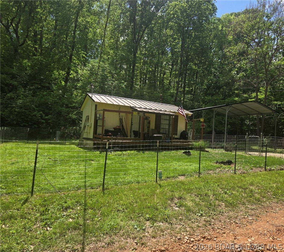 This affordable cabin in the woods is a smart pick for investors, weekenders, or anyone wanting a low-maintenance getaway. Minutes from the lake and the new Ozark International Raceway, it’s ideal for short-term rentals, hunting retreats, or long-term tenants. Recent updates include new appliances, new front door, new faucets, new glass sliding shower door, and fresh interior paint. Cozy woodstove keeps winter heating costs low. The layout offers a kitchen, bathroom, living area, and a raised loft over the washer/dryer hookups—great for sleeping space or storage. Quiet setting with wildlife and room to add value. Water is Ivy Bend Water District; private septic. Parking for 2–3 vehicles and extra space to the left for a garden or the option to enclose the carport for a detached garage. A solid income-producing opportunity at an accessible price.