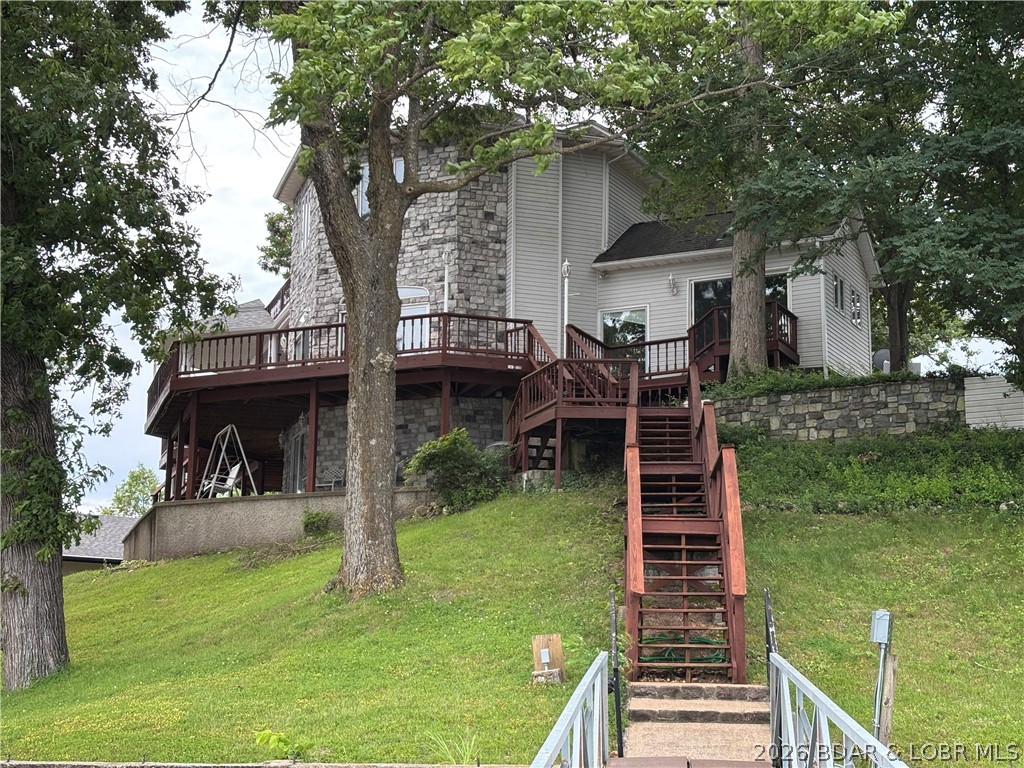 Outstanding 5-BR home (1 non-conforming) w/4 full baths—perfectly suited for a large family, multi-generational living, or a corporate/retreat-style getaway. Located in a welcoming neighborhood, you’ll enjoy a community pool just steps from your front door, along w/access to a boat ramp & picnic area. Designed for gathering, this home features a unique, non-cookie-cutter floor plan w/expansive living spaces ideal for hosting groups. Kitchen offers 2 large dining areas, creating the perfect setting for holiday celebrations, team retreats, or extended family stays. The living room is wrapped in sliding doors that frame breathtaking, panoramic views of wide-open water.  The home truly shines as a year-round retreat, featuring a lakeside indoor recreation room complete with hot tub & sauna—ideal for relaxing after a day on the water or team-building activities. The oversized primary suite includes a private bath, offering a quiet escape from the main living areas.  Outside, the property is built for lake life at scale, w/a 2-well concrete dock & 2 boat hoists plus 160' of seawalled LF at the desirable 46 MM—perfect for boating, entertaining & creating unforgettable group experiences.