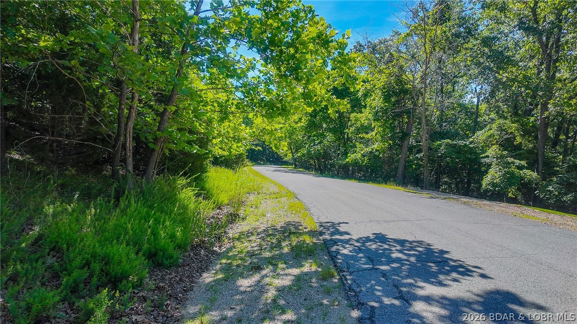 Embrace a fresh opportunity to build your dream retreat on Lot 251 in the prestigious Porto Cima community. This exceptional lake-view lot slopes toward the road, allowing you to position and build your future home with the intentional advantage of capturing a more expansive view of the lake over the lakefront homes. Located in one of Lake of the Ozarks' most sought-after neighborhoods, the property features a rich suite of community amenities, including lake access, sparkling pools, outdoor entertainment areas, an exercise room, and full access to the extensive Four Seasons amenities. To preserve the integrity and value of the neighborhood, the Property Owners Association (POA) requires the construction of a home with a minimum of 1,100 square feet, or a footprint equivalent to the beautiful homes already established around it. Bring your vision to life, seize this chance to unlock an unparalleled lakeside lifestyle, and start your next chapter today.