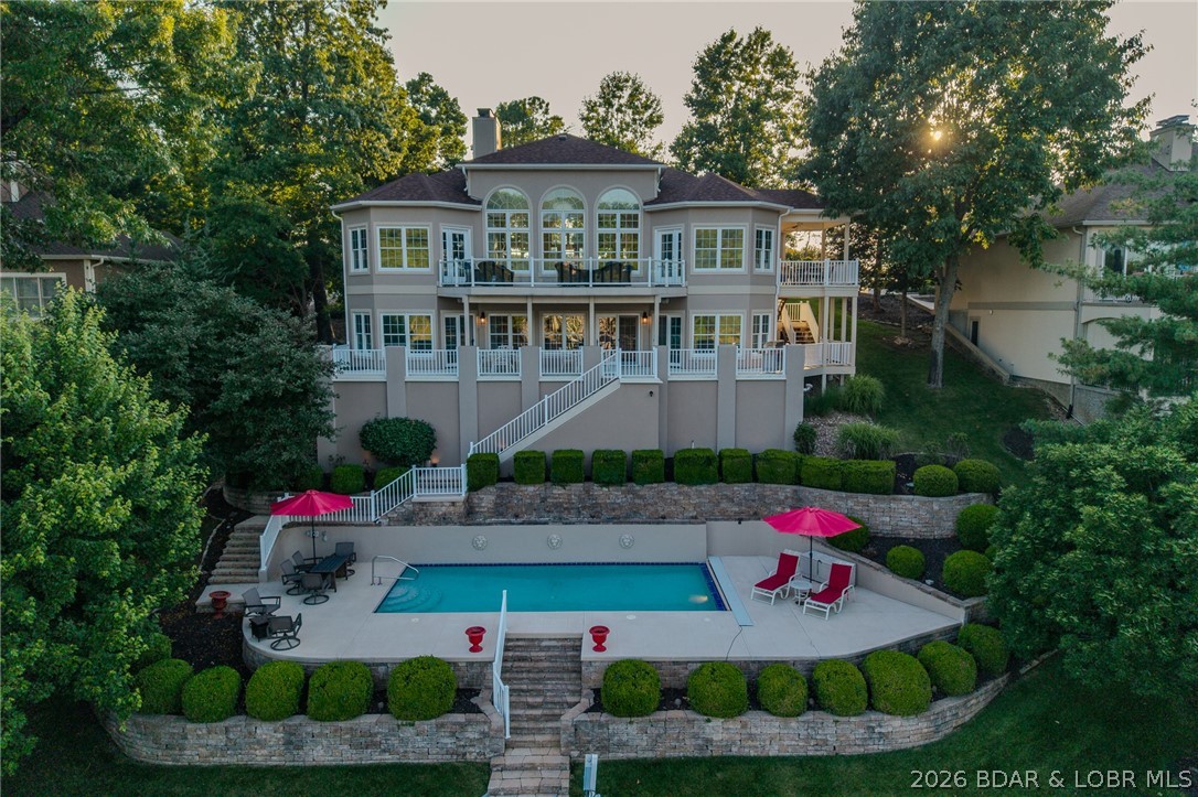 This newly remodeled home checks all of the boxes--premier address by land and water, spacious yet manageable size, gentle topography with large flat driveway, cove location with main channel view, private pool, & custom concrete dock!! Located at one of the most sought after addresses in Porto Cima--Muirfield Court, you are only minutes from shopping & restaurants by both land and water. From the time you drive up the long landscaped drive you feel welcomed with the wall of arched windows and new wide plank luxury vinyl flooring. Classy furnishings and decor throughout blend stye with comfort. The upper level features open living, dining, and kitchen with a large primary ensuite and easy access to both covered and uncovered decks to enjoy the spectacular main channel views. Kitchen accents include quartz counters and backsplash and stylish cabinet pulls. Ensuite updates include custom double vanity, soaking tub, tile shower and black marble accent wall. Lower level features great room with wet bar, 3 guest suites, and 2 baths. Enjoy your large covered deck or step down to your lakefront private pool and large concrete dock--perfect for lake fun! You don't want to miss this one!