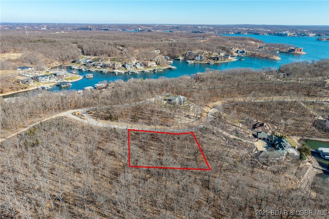 This Lakeview lot at The Villages at Shawnee Bend offers scenic views of the Lake of the Ozarks paired with the amenities of a premier master-planned community. Enter through the striking grand waterfall entrance and experience a neighborhood designed for both relaxation and recreation. Homeowners enjoy a welcoming clubhouse, multiple community pool, championship tennis courts, and pickleball facilities, as well as parks, and playgrounds. With paved roads and underground utilities in place, this lot is ready for a thoughtfully designed home that captures the lake views while embracing a vibrant, resort-style atmosphere.