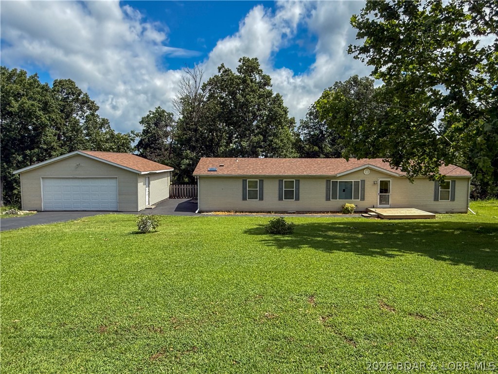 Enjoy privacy, space and a convenient location with this 3 bedroom, 2 bath home sitting on just over 3 acres. The home offers comfortable one level living, a large and open living room and a primary bedroom with a private bath. The kitchen appliances will remain, making the home ready for its next owner to move in and begin adding their own personal touches. Outside, the fenced yard connects directly to the home and provides a great space for pets, children or gardening. The 24 x 30 detached garage includes electricity and offers room for parking, storage or a workshop. A new roof adds value and peace of mind, while blacktop access leads all the way to the property. Tucked away with comfortable space between neighboring homes, the property still offers convenient access to the nearby movie theater and golf course, restaurants and grocery store. Some flooring and cosmetic updates are needed, giving buyers an opportunity to make the home their own while enjoying the acreage, privacy and location from day one.