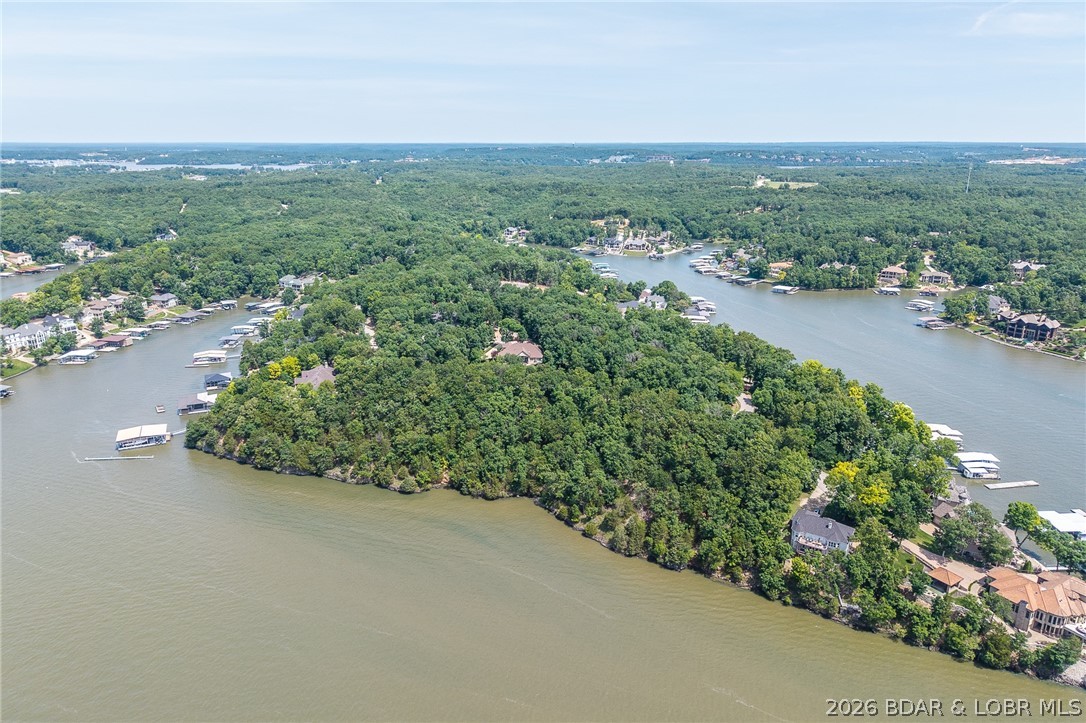 This premier Lakefront lot at The Villages at Shawnee Bend delivers the ultimate Lake of the Ozarks lifestyle with direct water access and breathtaking shoreline views. Arrive through the iconic grand waterfall entrance and enjoy a community known for its upscale amenities and attention to detail. Residents have access to a community marina, elegant clubhouse, multiple pools, championship tennis courts, and pickleball facilities, along with park and playground areas. With paved roads and underground utilities already in place, this lot is perfectly suited for a custom lakefront home with dock potential. A rare opportunity to own lakefront property in one of the lake’s most distinctive communities.